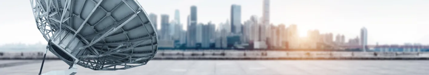 Satellite dish with a city in the background